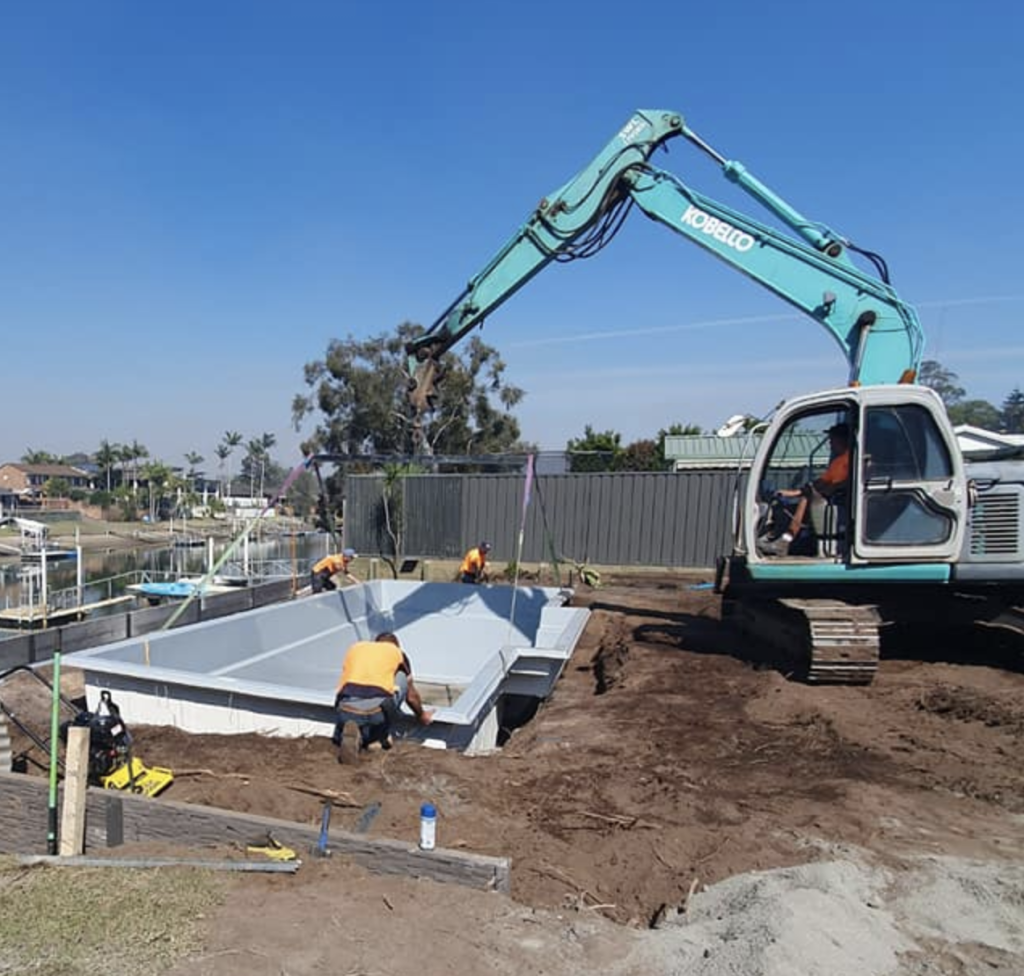 Putting in a pool using excavation equipment
